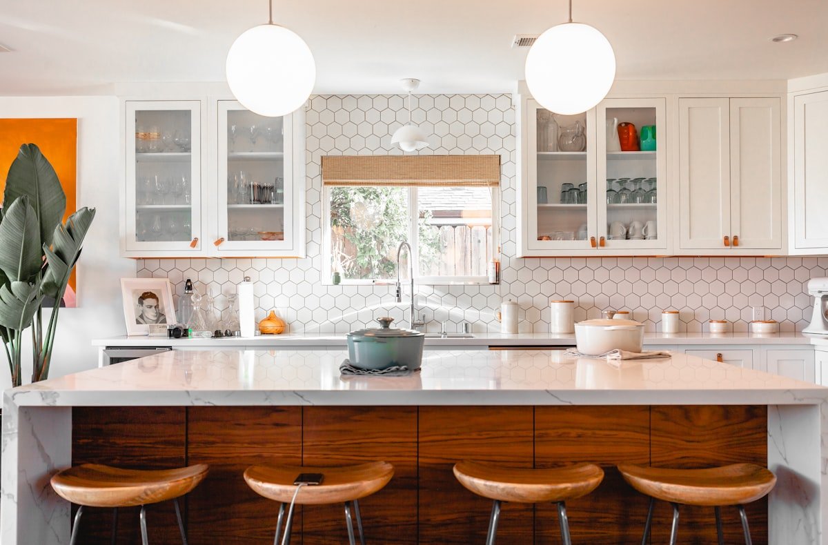 Kitchen with white cabinetry, wood island and pendant lights